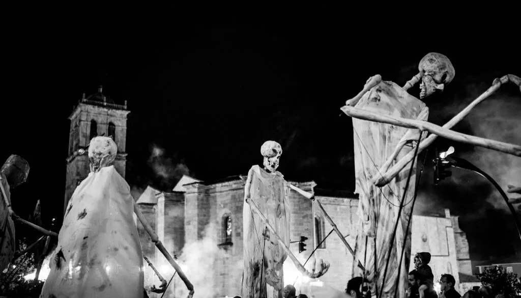 Ánimas gigantes del Desfile de las Ánimas de Soria frente a una iglesia, de noche