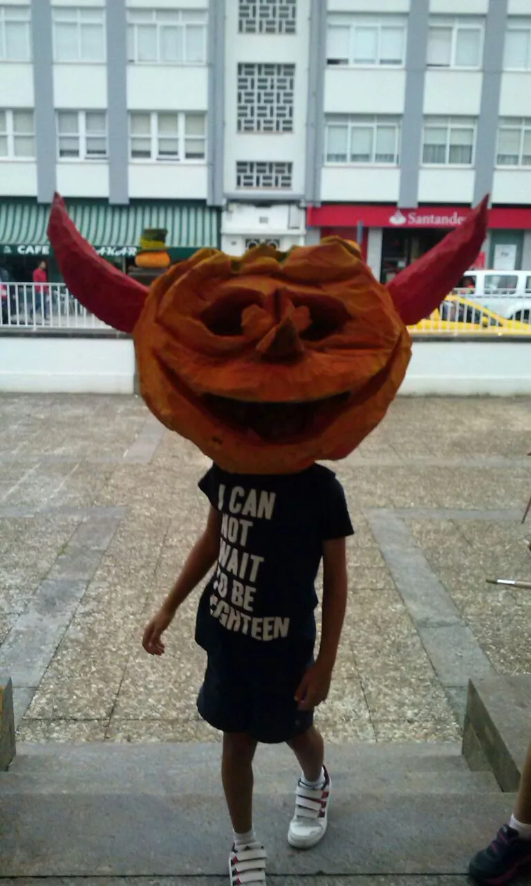 Niño con una gran cabeza de calabaza con cuernos en el Samaín de Cedeira